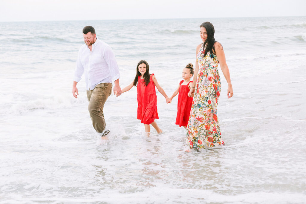 Family walking in water water in pops of red color, JCrane Photography, Best family photographer in North Carolina, Top-rated family photographer North Carolina, Outdoor Family Photographer Near Me