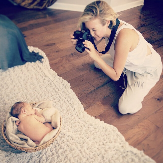 Jenna carefully photographing a newborn baby during a photography session, demonstrating her experience and gentle approach. JCrane Photography, Raleigh heirloom portraits, Raleigh portrait photography. Meet your Photographer.